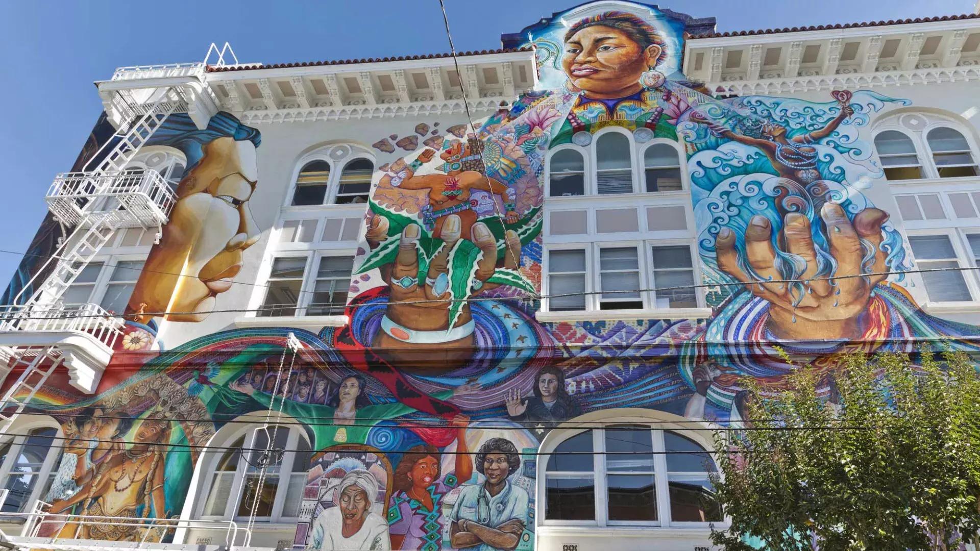 A colorful, large-scale mural covers the side of the Women's Building in San Francisco's Mission District.