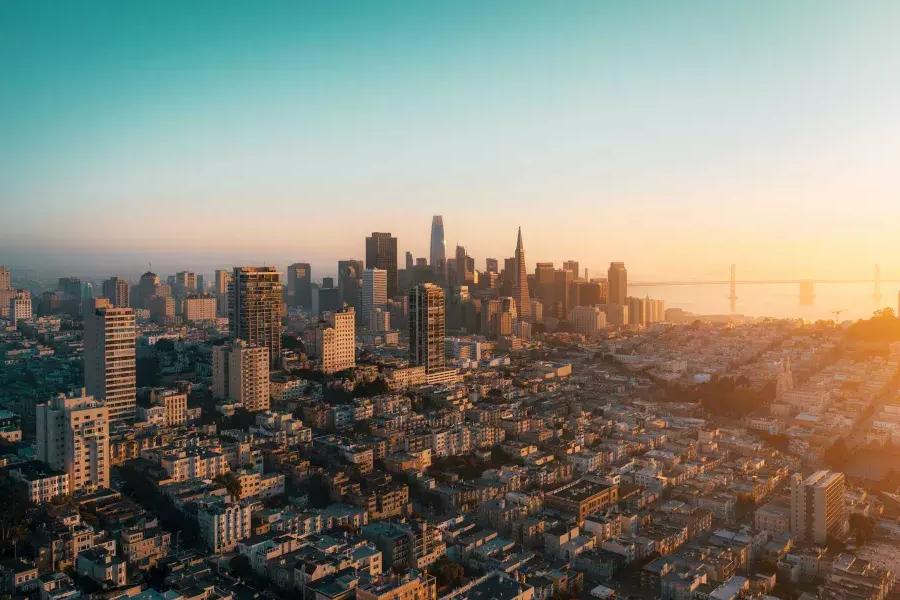 The skyline of San Francisco is seen from the air in a golden light.